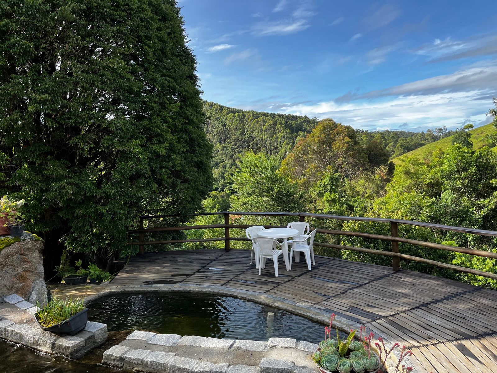 Casa Celino ao fundo e piscina natural cercada por deck de madeira